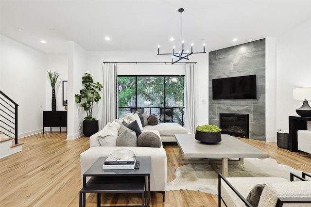 354 Foch St, Fort Worth, TX 76107 - living area with stairs, light wood finished floors, a chandelier, a tile fireplace, and recessed lighting