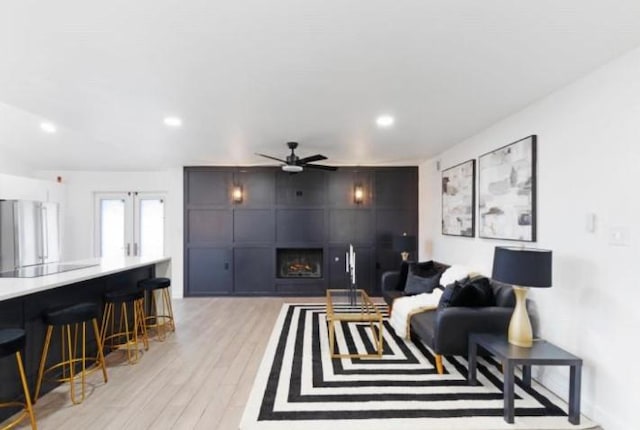 10669 Larchfield Ln, Dallas, TX 75238 - living room with a ceiling fan, light wood-type flooring, a large fireplace, recessed lighting, and french doors