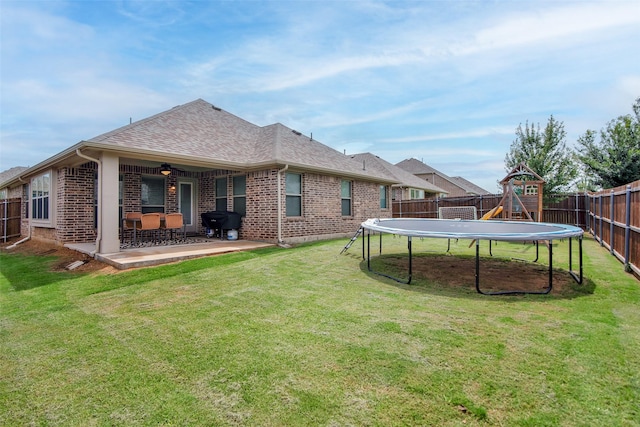 513 Endicott Dr, Sherman, TX 75092 - rear view of property featuring a trampoline, brick siding, a fenced backyard, and a patio area