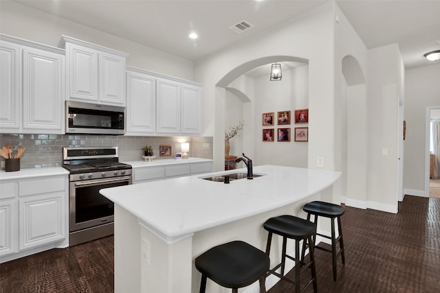 513 Endicott Dr, Sherman, TX 75092 - kitchen with stainless steel appliances, a breakfast bar area, backsplash, dark colored carpet, and a kitchen island with sink