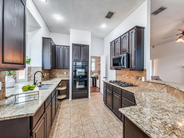 1728 Forest Glen Dr, Flower Mound, TX 75028 - kitchen with stainless steel microwave, gas cooktop, backsplash, light stone countertops, and a textured ceiling