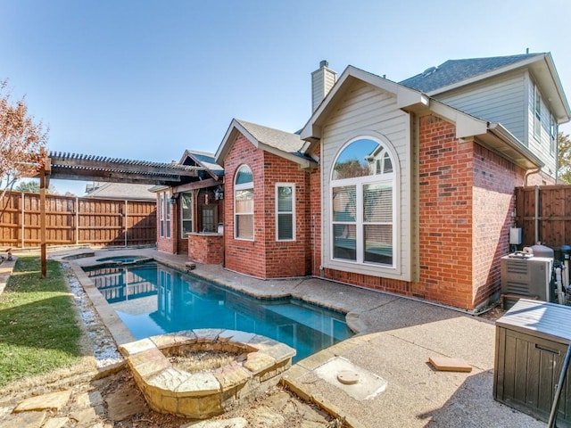 1728 Forest Glen Dr, Flower Mound, TX 75028 - rear view of house with brick siding, a chimney, a pool with connected hot tub, a fenced backyard, and an outdoor fire pit