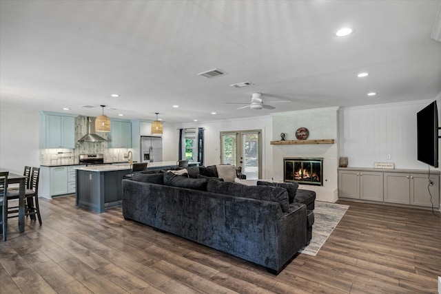 213 N Oaks Dr, Grand Saline, TX 75140 - living room with ornamental molding, dark wood-type flooring, a ceiling fan, a large fireplace, and recessed lighting