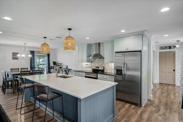 213 N Oaks Dr, Grand Saline, TX 75140 - kitchen featuring stainless steel appliances, wall chimney range hood, backsplash, dark wood finished floors, and pendant lighting