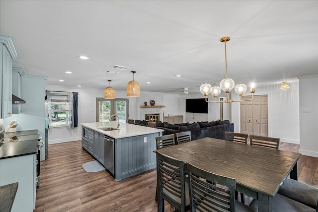 213 N Oaks Dr, Grand Saline, TX 75140 - dining area with dark wood-type flooring, a lit fireplace, recessed lighting, a chandelier, and crown molding