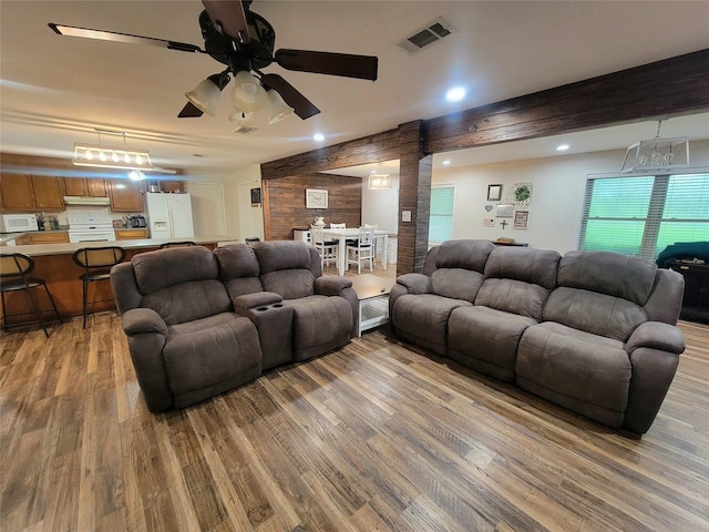 800 County Road 1030, Mount Pleasant, TX 75455 - living room with light wood-type flooring, a ceiling fan, and wooden walls