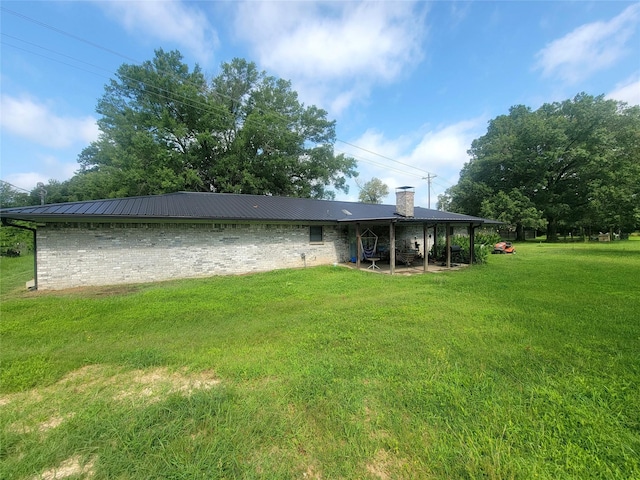 800 County Road 1030, Mount Pleasant, TX 75455 - back of property featuring a chimney, a metal roof, and a lawn