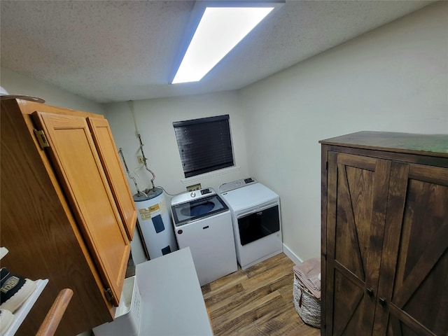 800 County Road 1030, Mount Pleasant, TX 75455 - laundry area featuring washing machine and dryer, electric water heater, light wood-style floors, and a textured ceiling