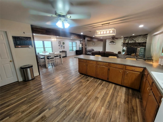 800 County Road 1030, Mount Pleasant, TX 75455 - kitchen featuring ceiling fan, open floor plan, brown cabinets, a large fireplace, and dark wood finished floors