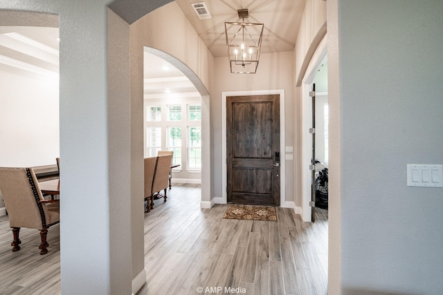 408 Lake Arbor Dr, Weatherford, TX 76088 - foyer entrance featuring a chandelier, arched walkways, light wood-style floors, and a textured wall