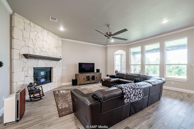 408 Lake Arbor Dr, Weatherford, TX 76088 - living area with crown molding, wood finished floors, ceiling fan, a stone fireplace, and arched walkways