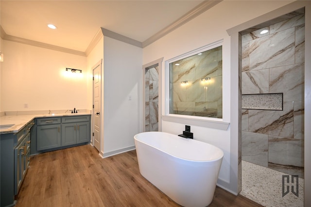 719 Germantown Rd, Minden, LA 71055 - full bathroom featuring ornamental molding, double vanity, wood finished floors, a marble finish shower, and a freestanding tub