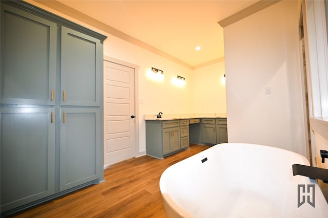 719 Germantown Rd, Minden, LA 71055 - bathroom featuring wood finished floors, a freestanding bath, vanity, ornamental molding, and recessed lighting