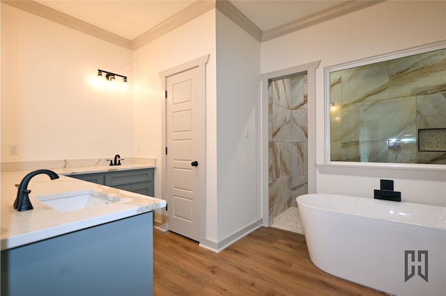 719 Germantown Rd, Minden, LA 71055 - bathroom with ornamental molding, wood finished floors, double vanity, a freestanding tub, and a walk in shower