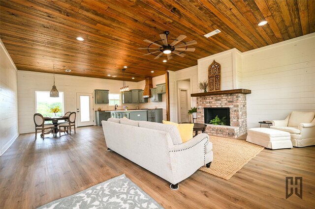 719 Germantown Rd, Minden, LA 71055 - living room with wooden ceiling, a ceiling fan, wood finished floors, wood walls, and a fireplace