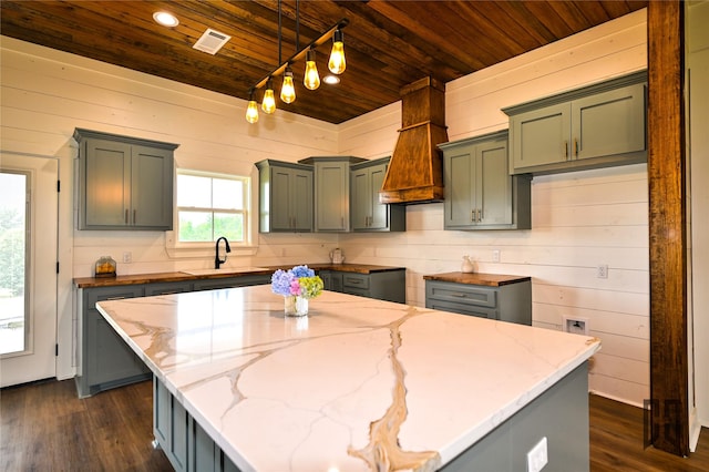 719 Germantown Rd, Minden, LA 71055 - kitchen featuring wood ceiling, light stone counters, dark wood finished floors, wood walls, and a center island