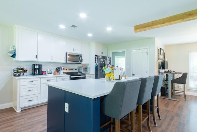 201 Roaring Springs Dr, Joshua, TX 76058 - kitchen with stainless steel appliances, a center island, a breakfast bar, tasteful backsplash, and white cabinets