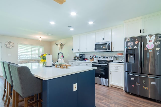201 Roaring Springs Dr, Joshua, TX 76058 - kitchen featuring appliances with stainless steel finishes, a breakfast bar area, white cabinets, decorative backsplash, and recessed lighting