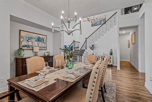 2010 Topaz Dr, Rockwall, TX 75087 - dining area featuring a chandelier, wood finished floors, ornamental molding, and stairs