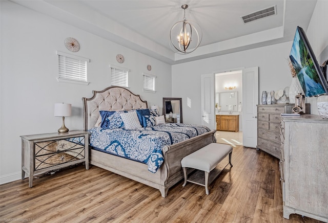 2010 Topaz Dr, Rockwall, TX 75087 - bedroom with a chandelier, a tray ceiling, light wood-style floors, and ensuite bathroom