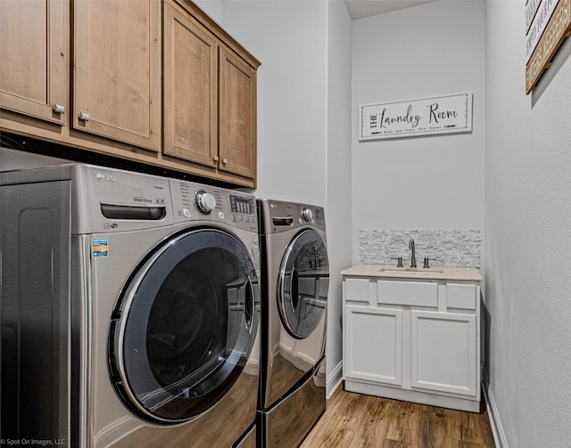 2010 Topaz Dr, Rockwall, TX 75087 - laundry room featuring separate washer and dryer, cabinet space, and light wood finished floors