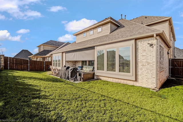 2010 Topaz Dr, Rockwall, TX 75087 - rear view of house with a shingled roof, a fenced backyard, brick siding, outdoor lounge area, and a patio