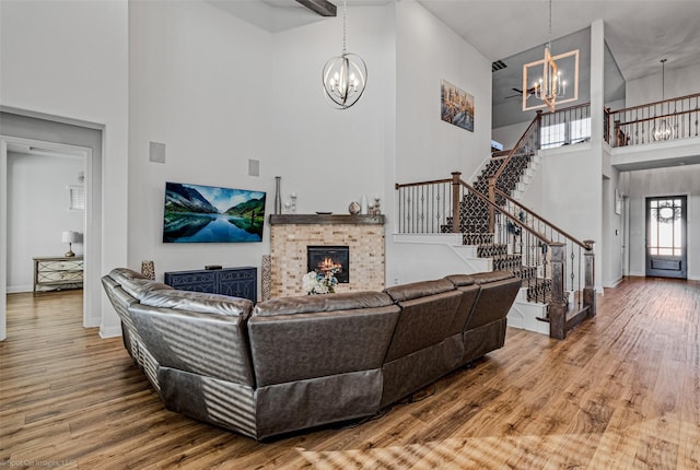 2010 Topaz Dr, Rockwall, TX 75087 - living area featuring a chandelier, a towering ceiling, stairway, wood finished floors, and a fireplace