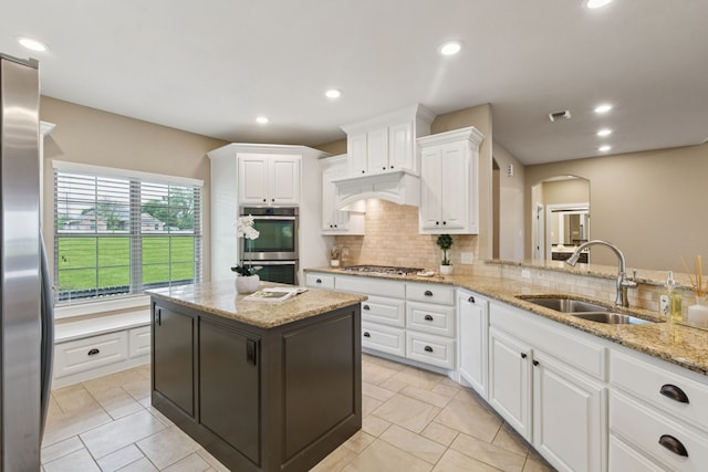320 Tate Cir, Sherman, TX 75090 - kitchen with stainless steel appliances, backsplash, white cabinetry, arched walkways, and light stone countertops