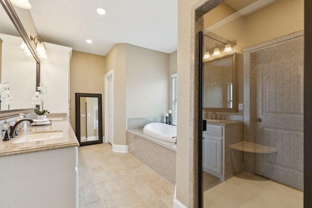 320 Tate Cir, Sherman, TX 75090 - bathroom with two vanities, a bath, a walk in shower, recessed lighting, and tile patterned floors