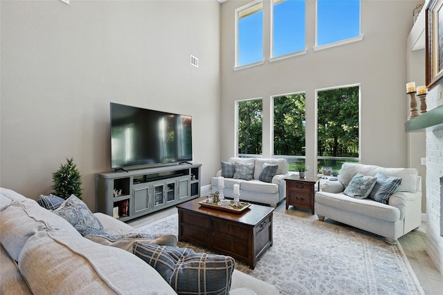 730 Emerald Sound Blvd, Oak Point, TX 75068 - living room with a high ceiling, wood finished floors, and a brick fireplace