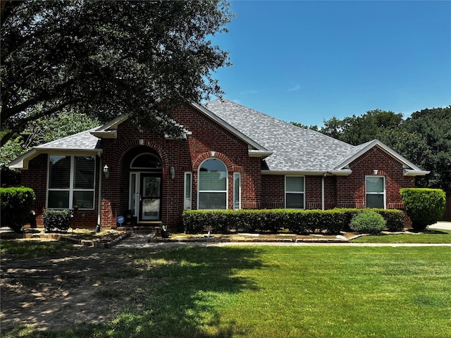 100 Palomino Ct, Shady Shores, TX 76208 - view of front of house with brick siding, roof with shingles, and a front yard