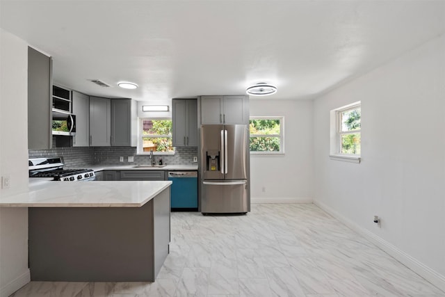 1228 Brookside Dr, Hurst, TX 76053 - kitchen with appliances with stainless steel finishes, gray cabinets, open shelves, and tasteful backsplash