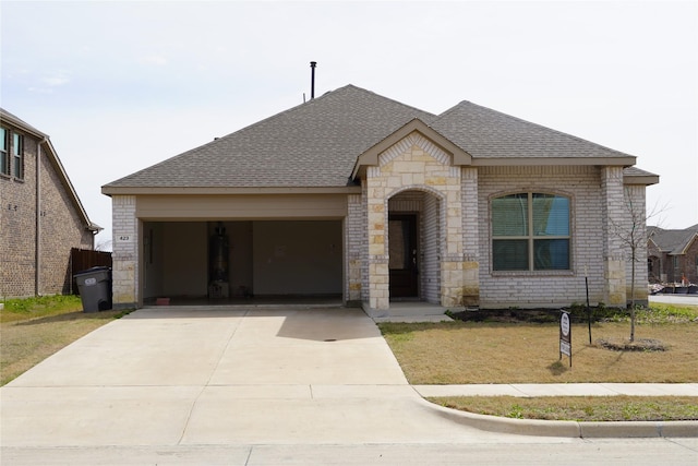 423 Pepperbark Ave, Princeton, TX 75407 - french country home featuring an attached garage, roof with shingles, brick siding, driveway, and stone siding