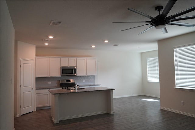 423 Pepperbark Ave, Princeton, TX 75407 - kitchen featuring stainless steel appliances, a kitchen island with sink, dark wood-style flooring, recessed lighting, and white cabinetry