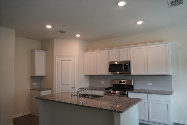 423 Pepperbark Ave, Princeton, TX 75407 - kitchen with stainless steel appliances, dark stone countertops, white cabinetry, a center island with sink, and recessed lighting