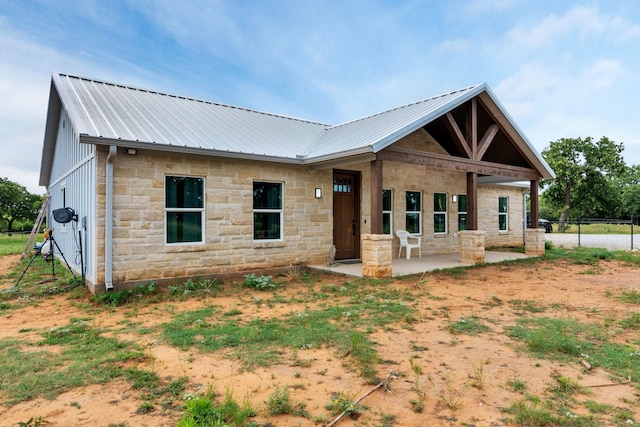234 Pumphrey Rd, Loving, TX 76460 - back of property with stone siding, a metal roof, and a patio