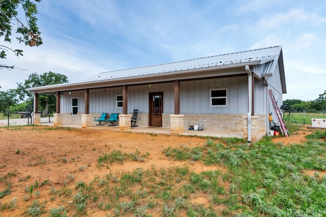 234 Pumphrey Rd, Loving, TX 76460 - view of front of home with board and batten siding, a metal roof, stone siding, and a patio