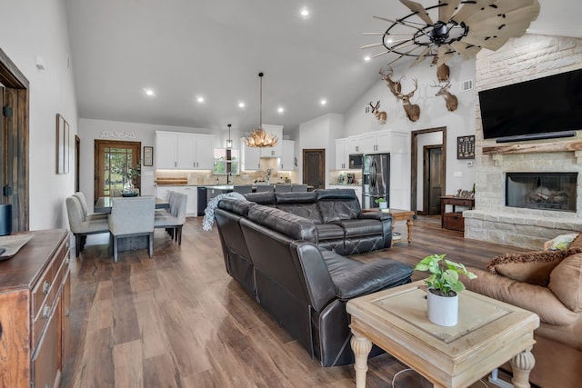 234 Pumphrey Rd, Loving, TX 76460 - living room featuring a stone fireplace, dark wood finished floors, high vaulted ceiling, recessed lighting, and a chandelier