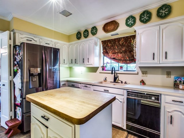 7204 Canongate Dr, Dallas, TX 75248 - kitchen featuring dishwasher, stainless steel fridge, butcher block countertops, a center island, and white cabinetry