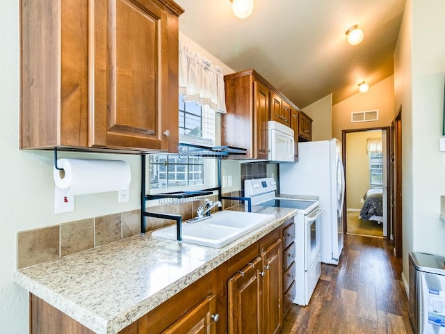 1045 Pelican Isle Dr, Kerens, TX 75144 - kitchen with white appliances, lofted ceiling, dark wood-type flooring, and brown cabinetry