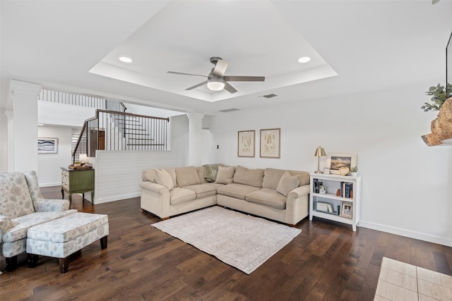 1702 Cheyenne Dr, Richardson, TX 75080 - living room featuring a tray ceiling, ornate columns, dark wood finished floors, ceiling fan, and stairs