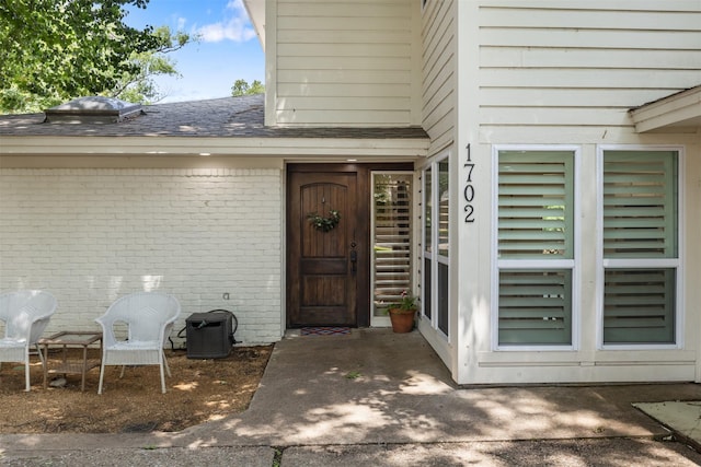 1702 Cheyenne Dr, Richardson, TX 75080 - property entrance featuring brick siding, roof with shingles, and a patio