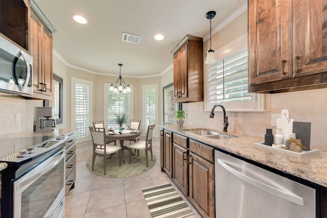 105 Windsor Dr, Forney, TX 75126 - kitchen with appliances with stainless steel finishes, light tile patterned flooring, ornamental molding, tasteful backsplash, and a chandelier