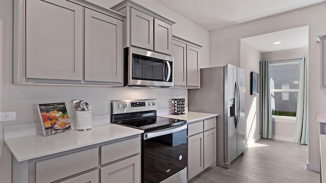 1525 Central Park Dr, Alvarado, TX 76009 - kitchen with appliances with stainless steel finishes, light wood-style flooring, gray cabinets, and light countertops