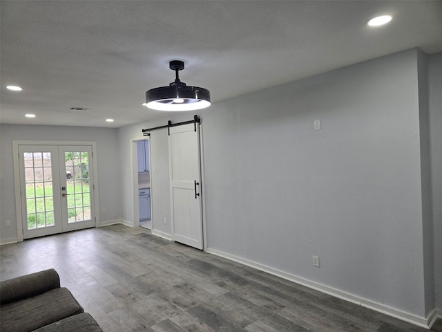 810 Shawnee Trce, Grand Prairie, TX 75051 - unfurnished living room with a barn door, recessed lighting, dark wood-style floors, and french doors