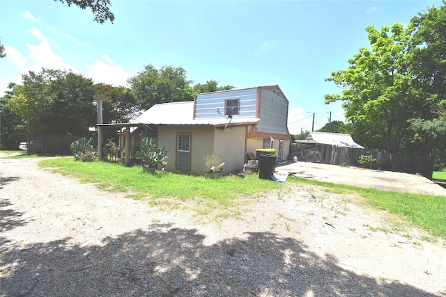 103 One Feather, Whitney, TX 76692 - view of property exterior with stucco siding and a metal roof