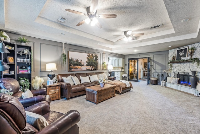 3244 Gail Ct, Irving, TX 75060 - carpeted living room with a raised ceiling, a textured ceiling, ceiling fan, and a fireplace