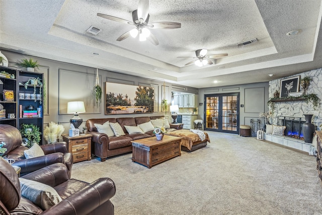 3244 Gail Ct, Irving, TX 75060 - living room featuring a raised ceiling, a textured ceiling, ceiling fan, carpet, and a fireplace