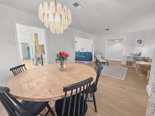 312 Meadowlark Dr, Richardson, TX 75080 - dining room featuring a chandelier, light wood-style floors, and crown molding