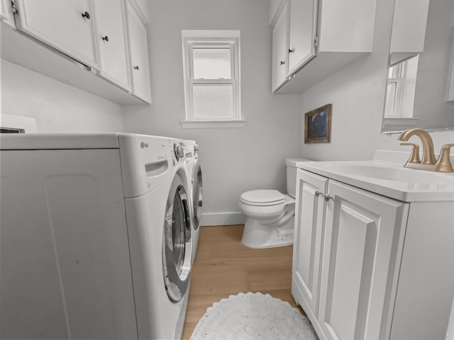 312 Meadowlark Dr, Richardson, TX 75080 - washroom featuring washer and clothes dryer and light wood-type flooring